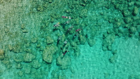 Group-of-SCUBA-divers-and-snorkelers-in-clear-shallows-of-Pefkos,-Rhodes