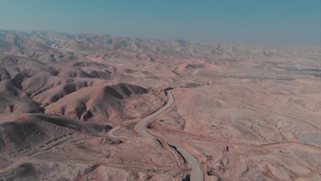 Drone-shot-of-a-desert-with-hills,-roads,-blue-sky