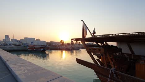 Verankertes-Traditionelles-Dau-Boot-Mit-Katar-Flagge-In-Der-Bucht-Von-Doha-Bei-Ruhigem-Sonnenaufgang-Am-Morgen