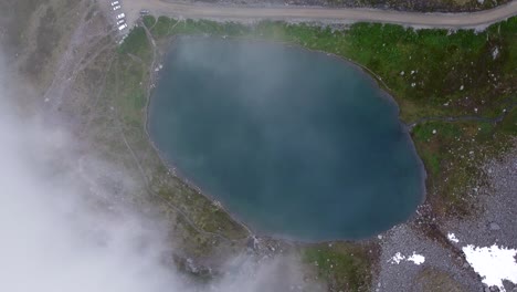 Lake-on-Top-of-Alaskan-Mountain-from-Above-getting-Covered-by-Cloud-During-the-Day-Hatcher-Pass