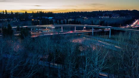 Aerial-hyperlapse-of-a-busy-and-interesting-freeway-interchange-at-sunset-with-mountains-in-the-background