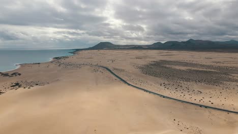 Drohnenflug-Wirft-Die-Küste-Von-Fuerteventura-Mit-Bergen-Im-Hintergrund-Und-Dem-Atlantik