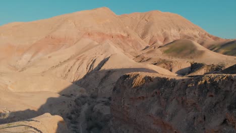 Drone-shot-of-a-desert-mounts,-Jurassic-park-look,-blue-sky