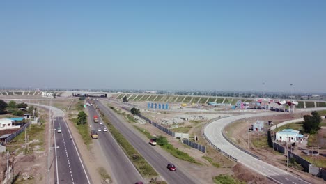 Niedrig-Aufsteigende-Luftdrohnenansicht-Des-Autobahnkreuzes-Samruddhi-Mahamarg,-Auch-Bekannt-Als-Nagpur-To-Mumbai-Super-Communication-Expressway,-Eine-Im-Bau-Befindliche-6-spurige-Autobahn