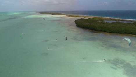 drone-shot-PEOPLE-KITESURF-IN-A-LINE-AT-HIGH-SPEED,-salinas-mangrove-los-roques