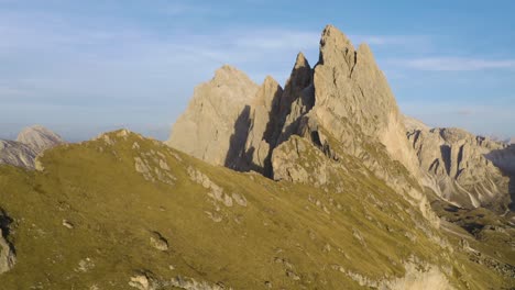 Drone-Flies-Away-from-Seceda,-Italy-on-Beautiful-Day-in-Mountains