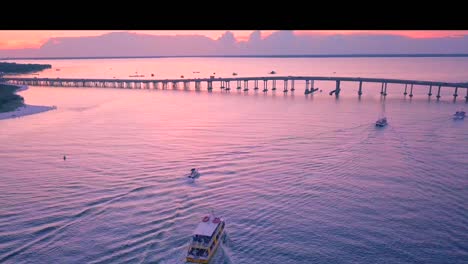Sonnenuntergang-Hinter-Einer-Brücke,-Wenn-Die-Fischerboote-Von-Ihrem-Tag-Auf-See-Zurückkommen