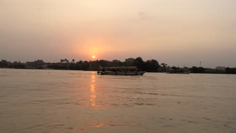 A-ferry-takes-passengers-down-the-Nile-River-near-Cairo,-Egypt-at-sunset