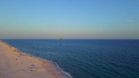 A-lone-paraglider-flying-peacefully-over-the-ocean-and-beach-at-the-end-of-the-day