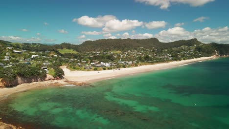 Drone-flying-over-trees-into-Hahei-bay-above-coral-reef