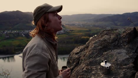 Young-Man-With-Long-Hair-Drinking-Coffee-Looking-To-Stunning-Landscape,-Vogelberg