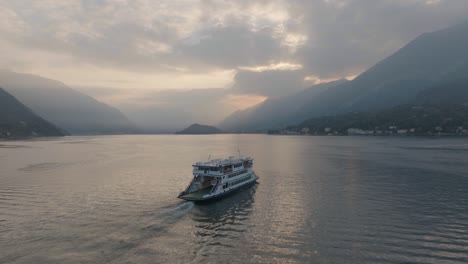 4K-Aerial---Sunset-Slowly-following-a-ferry-in-Lake-Como,-Italy