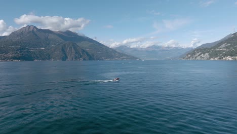 4K-Aerial---Following-medium-shot-and-slow-orbit-behind-a-classic-boat-in-Lake-Como,-Italy