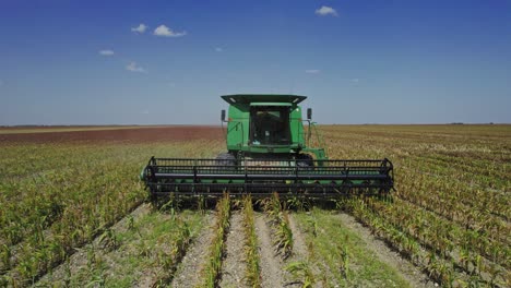 AERIAL---Combine-harvester-cultivating-land,-agriculture-field,-Mexico,-reverse-rising