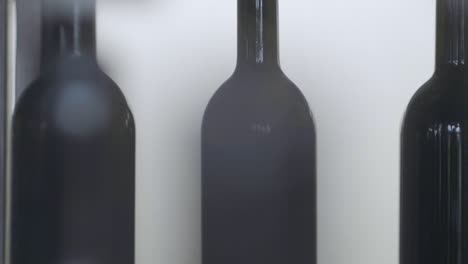 Makroaufnahme-Von-Rotwein,-Der-Von-Einer-Automatisierten-Maschine-Im-Weingut-In-Flaschen-Gefüllt-Wird