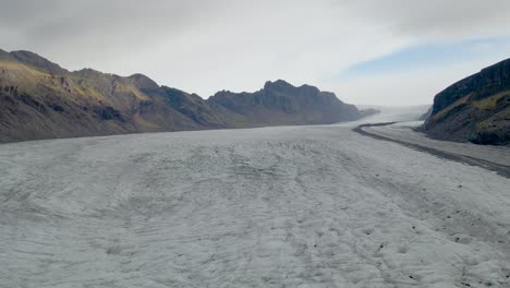 Stunning-aerial-view-of-Skaftafell-Glacier,-Tilt-down-reveal-Cracked-ice
