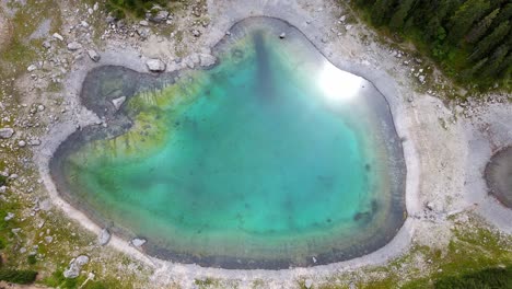 Aerial-views-of-the-carezza-lake,-one-of-the-most-beautiful-lakes-in-the-Dolomites,-Italy