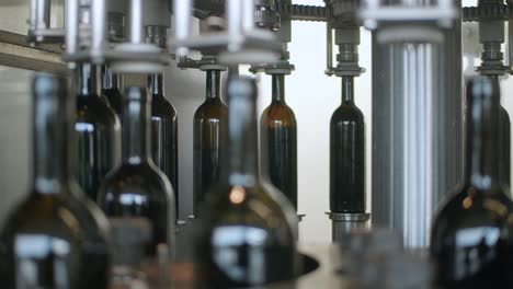 Primer-Plano-De-Vino-Tinto-Llenado-En-Botellas-Por-Máquina-Automatizada-En-Bodega