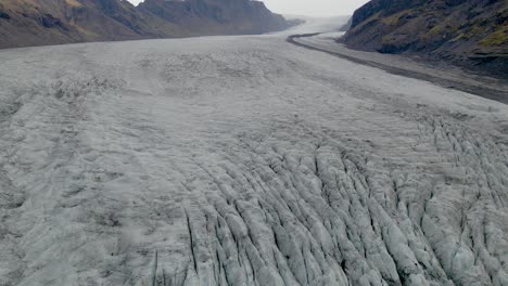 Aerial-pullback-shot-of-Skaftafell-Glacier,-Ice-rugged-pattern,-Icelandic-Landscape,-Tilt-up