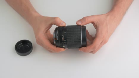 Man-rotating-the-focus-ring-of-a-camera-lens