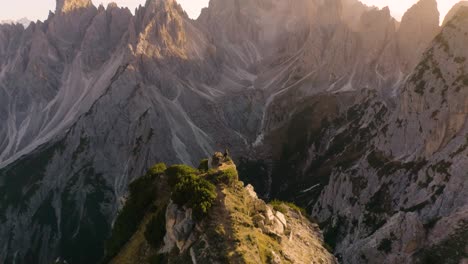 Dramatic-Aerial-Shot-Above-Cliff-Ridgeline-with-Italian-Dolomite-Mountain-Peaks-in-Background