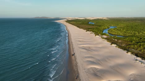 Aerial-flyover-coastline-of-Brazil-with-ocean,-sandy-beach-and-dunes-at-sunset-