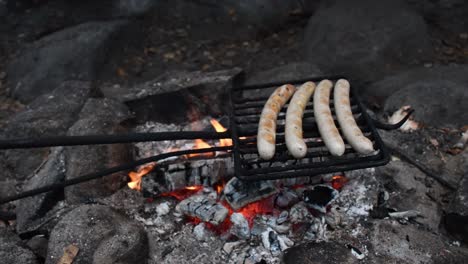 Grilling-sausage-bratwursts-on-open-camp-fire