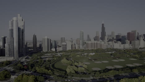 Aerial-drone-footage-flying-south-to-north-of-Grant-Park,-Willis-Tower-and-the-Chicago,-Illinois-Skyline-at-sunrise-in-the-fall-in-October