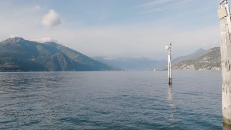 4K-Aerial---Slow-and-low-fly-past-mooring-posts-in-Lake-Como,-Italy