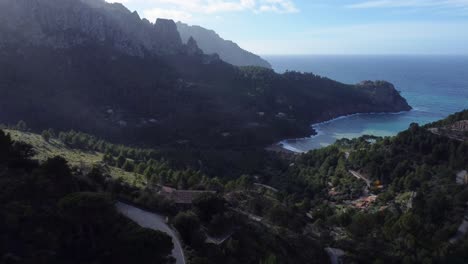 Drone-flying-towards-beach-between-mountains,-Cala-Tuent,-Mallorca