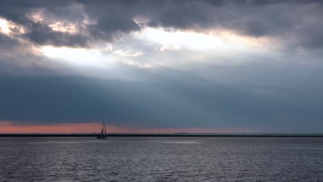 Ein-Sonnenuntergang-über-Dem-Eriesee-Mit-Einem-Segelboot,-Das-über-Das-Wasser-Segelt