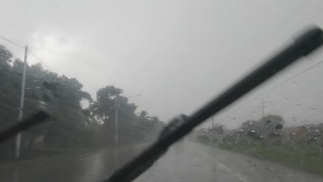 Interior-view-of-vehicle-on-its-way-to-the-cibao-highway-in-the-rain,-traveling-through-the-country
