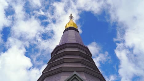 Typical-Thai-pagoda,-looking-up-against-blue-sky-with-clouds