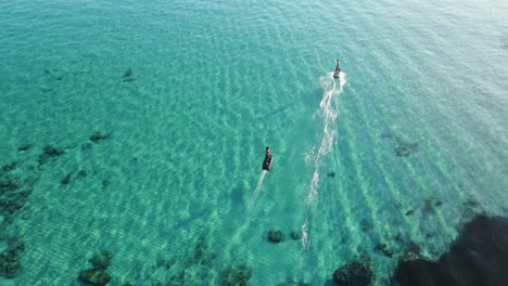 Aerial-of-some-people-surfing-along-the-coral-reef-in-Ibiza,-Spain