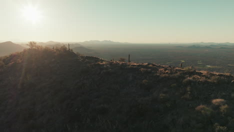 Aerial-tracking-of-Arizona-mountain-peak-at-sunrise,-looking-into-valley-below