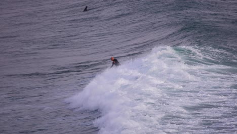 Surfers-catching-waves-in-Cascais,-Portugal