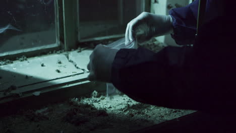 Crime-scene-investigation,-putting-evidence-into-plastic-bag,-detail-view-of-hands-in-gloves-at-night