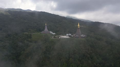 Impresionante-Vuelo-A-Través-De-Las-Nubes-Para-Revelar-Pagodas-Gemelas-En-Doi-Inthanon,-Tailandia