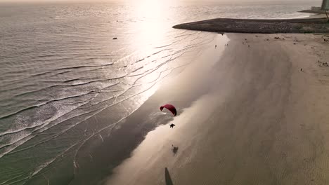 Aerial-shot-of-acro-paragliding-at-a-beach-in-Karachi-at-sunset