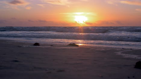 Schöner-Sonnenuntergang-Auf-Dem-Hintergrund-Der-Ostsee,-Sonne,-Die-über-Den-Horizont-Hinausgeht-Und-Wasser-Und-Wolken-Am-Himmel-Beleuchtet,-Ruhige-Meereswellen,-Romantische-Stimmung,-Kopierraum,-Niedrige-Weitwinkelaufnahme