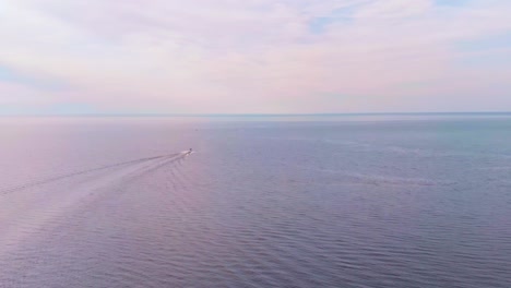 Aerial-Shot-Of-One-Boat-Sailing-In-Heart-Of-Blue-Ocean-Creating-Long-Trail-Foam