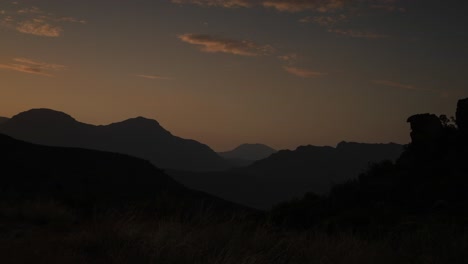 Time-Lapse-of-sunset-over-a-mountain-range-stretching-across-the-horizon
