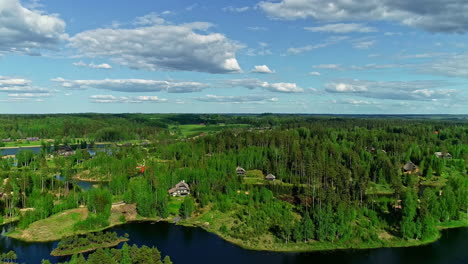 Langsam-Rückwärts-Fliegender-Drohnenflug-über-Eine-Wunderschöne-Bunte-Waldlandschaft-Mit-Häusern-An-Einem-See-Ist-Wie-Ein-Märchenhafter-Anblick