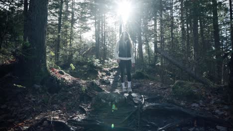 Young-Caucasian-Woman-Hiking-Through-The-Forest-With-Morning-Sunlight