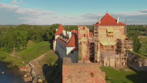 Aerial-Shot-Of-Bauska-Castle-Reconstruction-And-Renovation-In-Rural-Area,-Zemgale