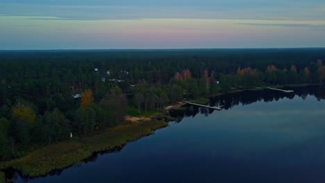 high-drone-flight-over-a-large-lake-with-many-moorings-in-the-twilight-of-the-evening