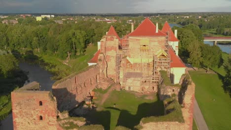 Jib-Shot-Of-Bauska-Castle-Reconstruction-And-Renovation-In-Rural-Area,-Zemgale