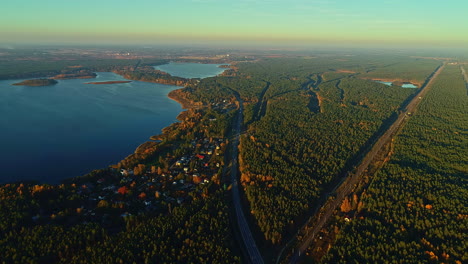 Vogelperspektive-Des-Natürlichen-Blauen-Sees,-Umgeben-Von-Goldenen-Bäumen-Bei-Sonnenuntergang-Im-Herbst