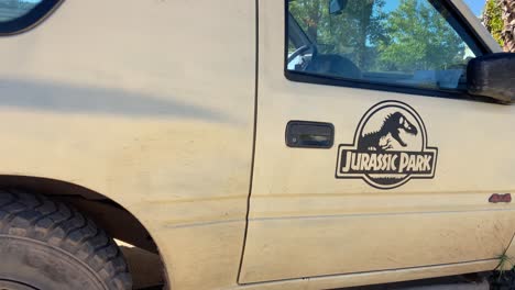 Jurassic-Park-sticker-on-the-side-of-a-beige-parked-off-road-car