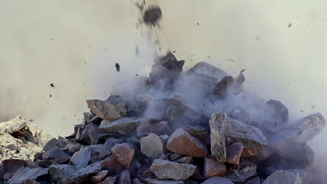 Dumping-a-pile-of-stones-at-a-construction-site-in-isolated-slow-motion-with-dust-and-debris-flying-everywhere